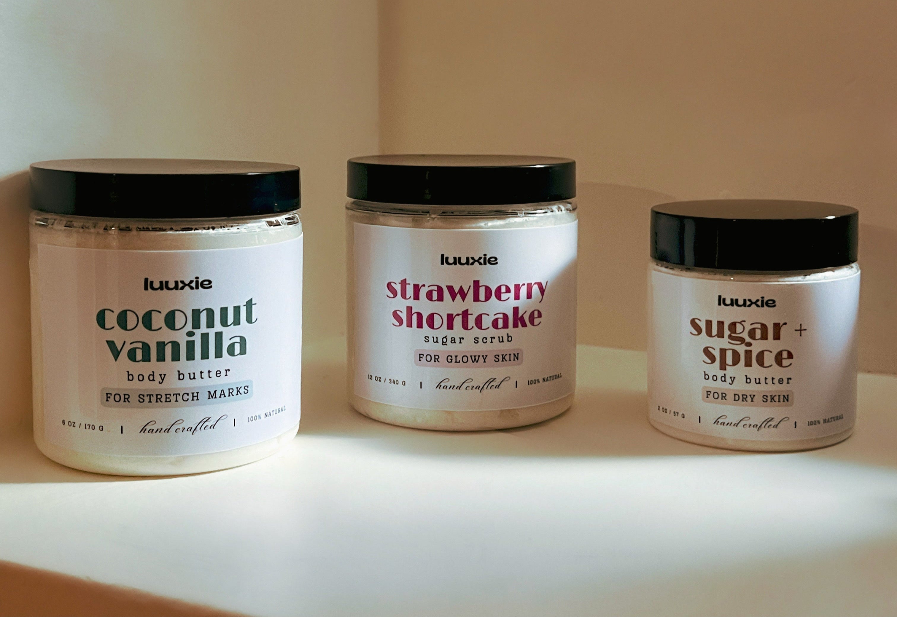 Three jars of luuade body products on a neutral background